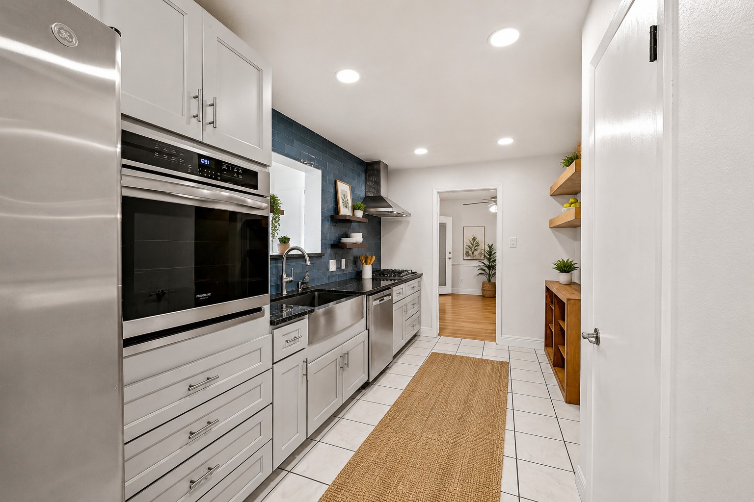 Galley view of kitchen with farmhouse sink and wall oven
